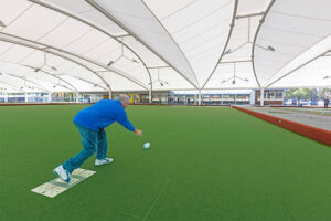 Man playing lawn bowls under Bowling Green Canopy